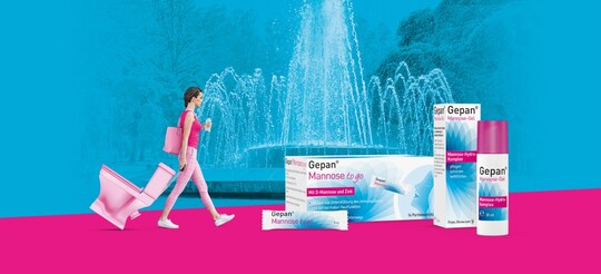 Pflege Deine Abwehrkräfte mit den Gepan Mannose Produkten von Pohl-Boskamp Junge Frau in rosa Kleidung zieht eine rosa Toilette wie einen Koffer hinter sich her. im Hintergrund ein Springbrunnen und im Vordergrund die Gepan Produkte von Pohl-Boskamp