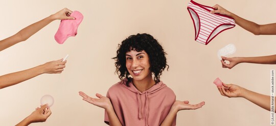 Eine junge Frau umringt von Händen, die verschiedene Perioden-Produkte ins Bild halten.