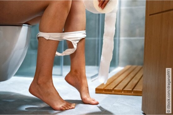 So erkennt man eine Blasenentzündung in der Schwangerschaft Schwangere Frau auf Toilette mit Toilettenpapier in der Hand