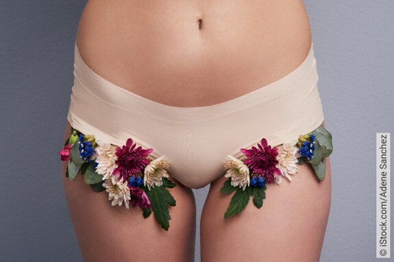 Frauen-Unterleib in beiger Panty, verziert mit bunten Blüten an den Beinausschnitten.